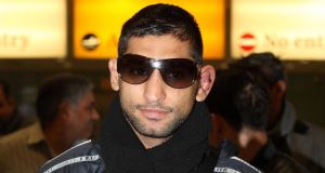 Amir Khan arrives at Heathrow Airport in London following his WBA and IBF light-welterweight titles defeat to Lamont Peterson in Washington