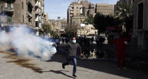 n Egyptian protestor throws a tear gas canister fired by security forces during clashes near the interior ministry in downtown Cairo