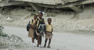 Children walk past collapsed buildings in Port-au-Prince, Haiti, which is struggling to rebuild itself after the earthquake two years ago.