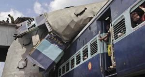 The roof of Uttarbanga Expresss passenger car sits on top of Vananchal Express as rescue workers search for survivors at  Sainthia station, about 200 kms north of Calcutta.