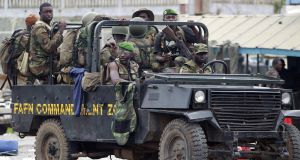 New Forces soldiers loyal to Alassane Ouattara drive at a checkpoint at one of the principal entrances to Abidjan, Ivory Coast today. New Forces soldiers loyal to Alassane Ouattara drive at a checkpoint at one of the principal entrances to Abidjan, Ivory Coast today.