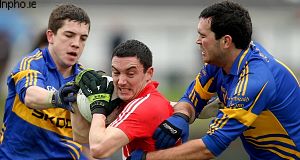 Tipperarys Seamus Grogan and Robbie Kiely tackle Kevin Harrington of Cork today.