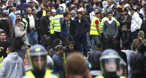 British police officers try to control anti-fascist protesters as they charge against anti-Muslim protesters in the London suburb of Harrow.