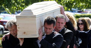 Povil Linderberg, left, Ruairi de Blacam, right, and Kevin Dolan, back carry the coffin of Mick Lally’s remains at Newlands Cross Crematorium this afternoon.