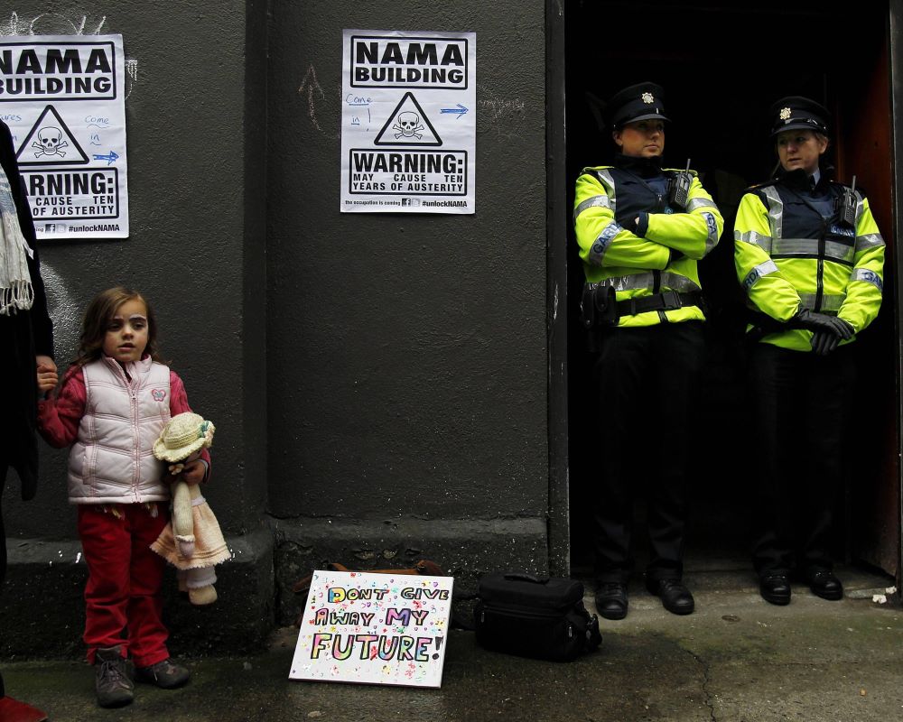 Orla Jennings, aged four, holds her father Peter Harris' hand outside the building.