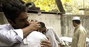 People hug each other in front of bodies of a bombing victims at a local hospital in Rawalpindi, Pakistan today. People hug each other in front of bodies of a bombing victims at a local hospital in Rawalpindi, Pakistan today.