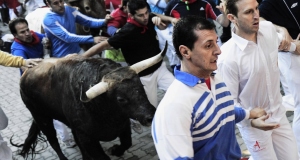 Revelers are chased by fighting bulls on the third day of the running of the bulls during the San Fermin festival in Pamplona yesterday. Revelers are chased by fighting bulls on the third day of the running of the bulls during the San Fermin festival in Pamplona yesterday.