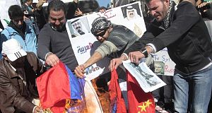 Anti-Syrian regime protesters and supporters of the Islamic Group Jamaa Islamiya, who are opposed to Syrian President Bashar Assad, burn Russian and Chinese flags in front the Russian embassy, in Beirut, Lebanon yesterday.