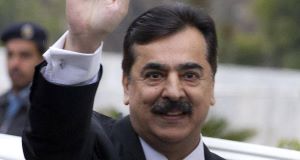 Pakistani Prime Minister Yousuf Raza Gilani waves upon his arrival at the Supreme Court for a hearing in Islamabad
